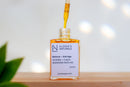 Elodie's Naturals: Open orange serum bottle and dropper