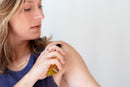 Elodie's Naturals: Woman holding body oil near shoulder
