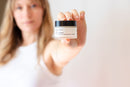 Elodie's Naturals: Woman holding closed lotion jar