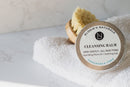 Elodie's Naturals: Cleansing balm lid beside brush and towel