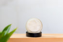 Elodie's Naturals: Open lotion jar resting on black lid