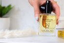 Elodie's Naturals: Hand holding uncapped body oil spray bottle