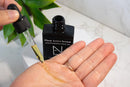 Elodie's Naturals: Dropper dispensing golden oil into a palm